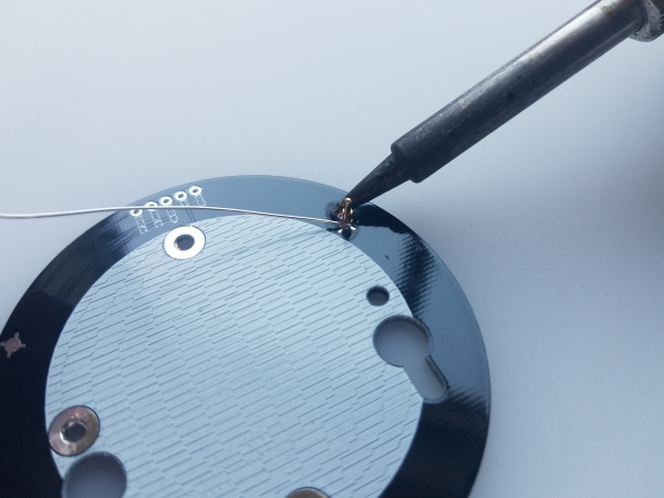 Close up view of a soldering iron tip making the necessary solder joint