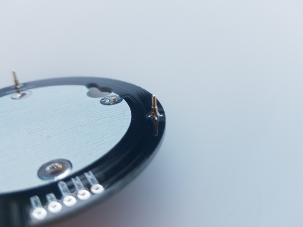 Macro shot of the completed solder joint showing an abundance of solder forming a rounded base around the pogo pin.