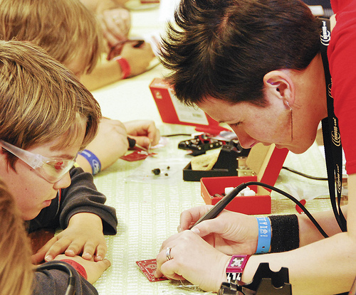 Lindsay helps a child solder in 2010