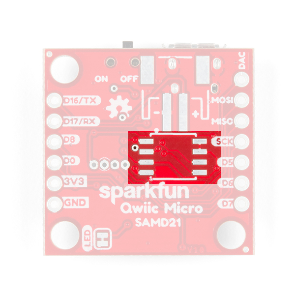 This image shows the bottom of the SparkFun Qwiic Micro and highlights a grouping of SMD pads located in the center the board where a flash chip can be soldered onto. 