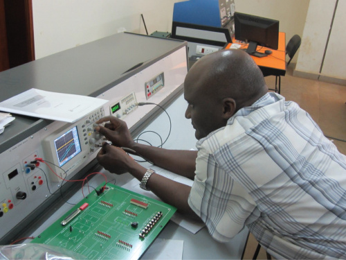 Instructor from Makerere showing the hardware his students use