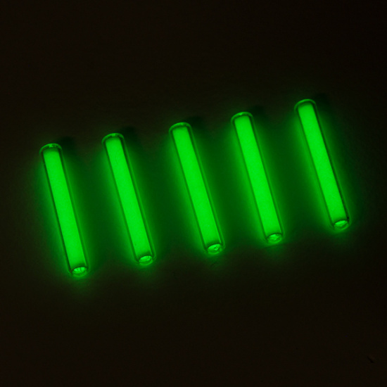 Several glowing green tritium tubes on a black background