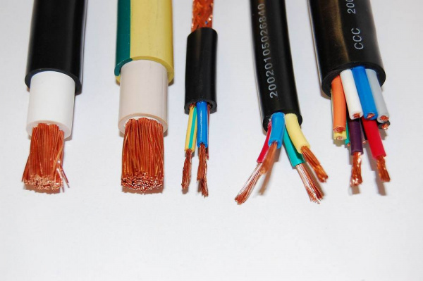 Electrical power cable close up. IEC standard color code. Cross-section  with cable jacket, wire insulations in brown, blue and yellow-green color  with flexible stranded copper wires. Macro photo. Stock Photo