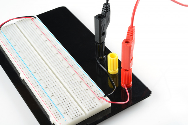 A breadboard being powered through the binding posts from banana cables