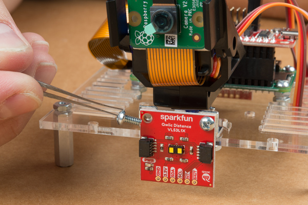 Time of flight sensor mounted to metal mounting brackets on mounting plate