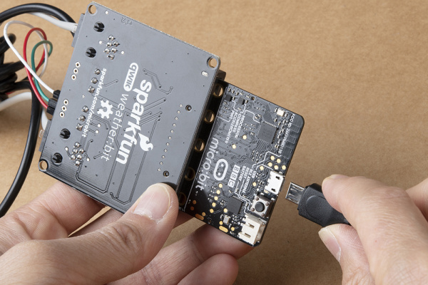 Inserting a USB Cable into the Micro:bit on the Weather Station's Side