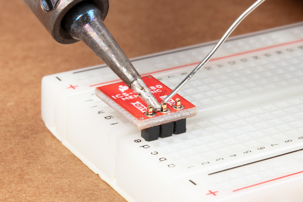 Straight header pins being soldered to MEMS microphone.