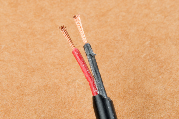 Electrical power cable close up. IEC standard color code. Cross-section  with cable jacket, wire insulations in brown, blue and yellow-green color  with flexible stranded copper wires. Macro photo. Stock Photo