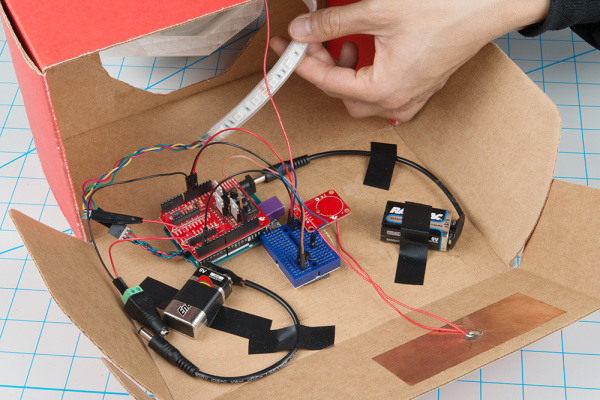 Circuit secured to bottom of cardboard box with electrical tape