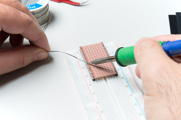 Soldering the headers to the base plate using a breadboard as a fixture